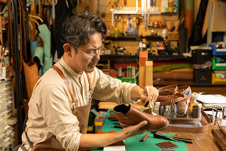中年男性工匠护理皮鞋图片