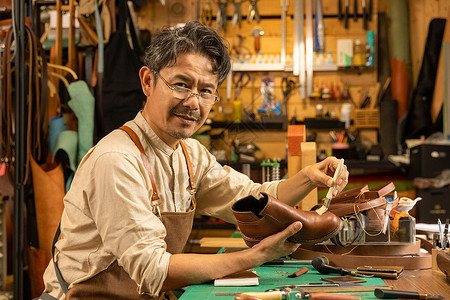 中年男性工匠护理皮鞋图片