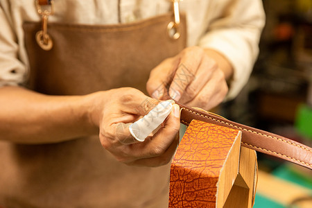 缝制车间中年男性皮匠手工缝制皮带细节背景