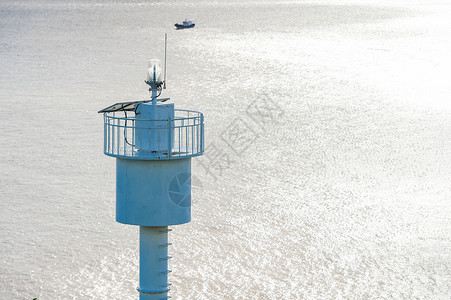 白天大海上的灯塔塔尖特写背景图片
