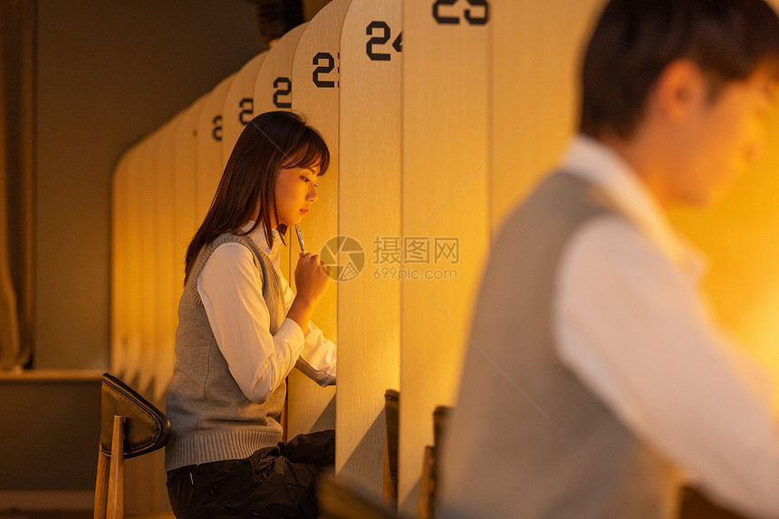 自习室内认真学习的甜美大学生图片