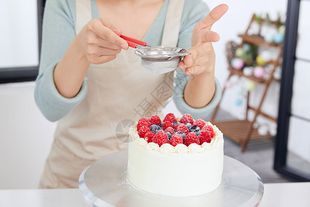 和面女人美女居家制作水果蛋糕撒糖粉背景