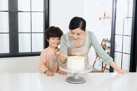 母子烘培手工制作蛋糕涂抹奶油背景图片