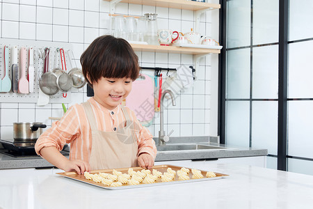 小朋友做蛋糕儿童小男孩拿托盘烤饼干背景