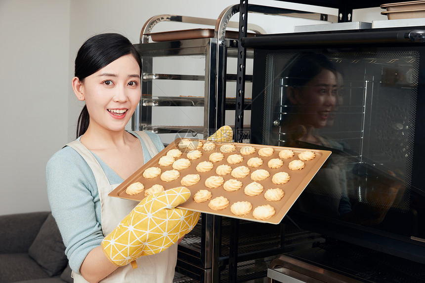 美女居家烘烤饼干拿托盘图片