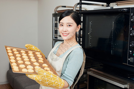 一盒饼干美女居家烘烤饼干拿托盘背景