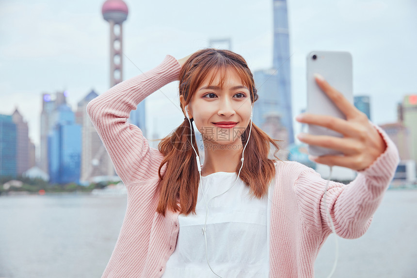 在外滩自拍的年轻女孩图片