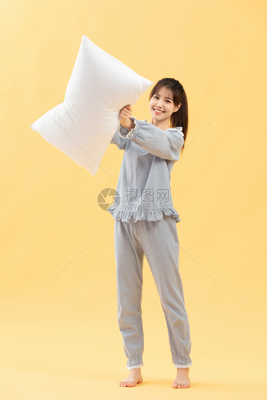 穿着睡衣的女孩手抱枕头图片