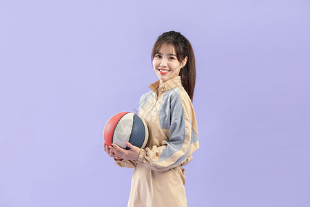 穿休闲服的甜美女性与篮球背景图片