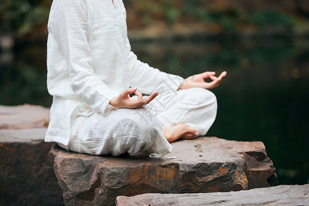 健身瑜伽女性石头上端坐的禅意瑜伽女性特写背景