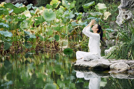 瑜伽莲花河边做瑜伽修身养性的女性背景