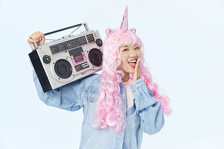 漂亮的烫发夹板录音机放在肩膀上的时尚粉色长发美女背景