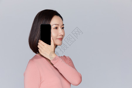 女性拿着手机展示耳朵图片