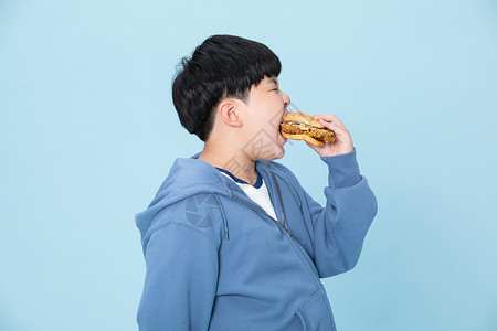 大袖衫小男孩大口吃汉堡肥胖的男孩背景