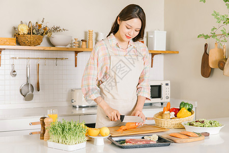 居家女性厨房牛排制作厨房切胡萝卜的甜美女孩背景