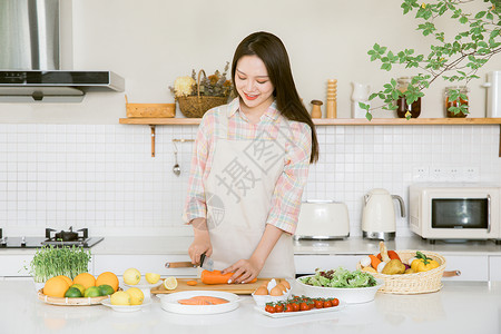 做饭女孩厨房切胡萝卜的甜美女孩背景