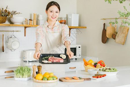 下厨的女士居家女性厨房牛排制作背景