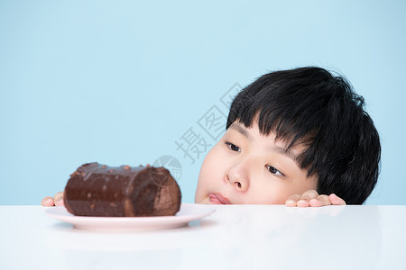 吃甜食的人盯着蛋糕看的小男孩背景