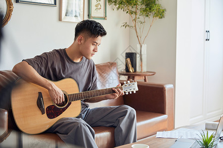 年轻男士在家弹吉他高清图片