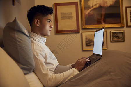 夜晚居家男士使用电脑加班办公图片