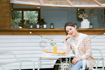户外喝下午茶的年轻女性精致生活高清图片素材