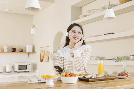 头戴耳机听音乐的女孩享受午餐高清图片