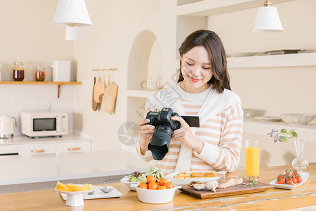 使用相机拍照的韩系女孩居家女孩使用相机拍摄美食背景