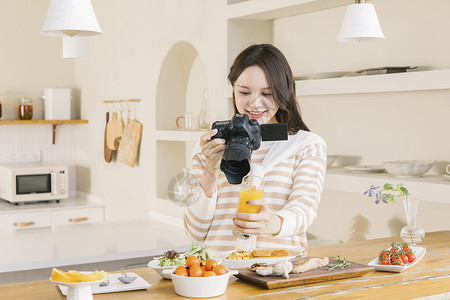 居家女孩使用相机拍摄美食高清图片