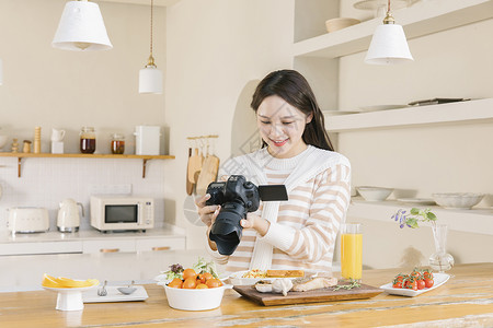 使用相机拍照的韩系女孩居家女孩使用相机拍摄美食背景