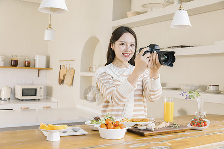 居家女孩使用相机拍摄美食图片