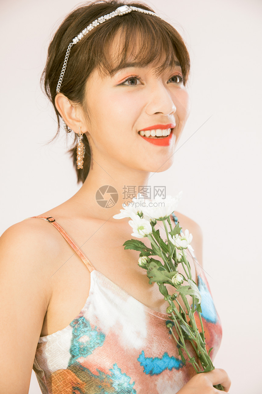 年轻美女手拿鲜花图片