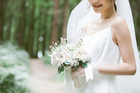 森林写真拿手捧花的甜美新娘特写背景