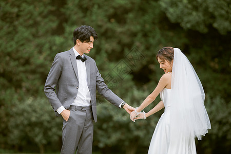 年轻情侣牵手婚纱照写真背景图片
