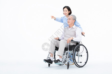 推着老人护士护士推着轮椅带老人散步背景