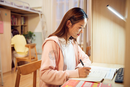 青少前女学生女大学生考研前在宿舍认真复习背景