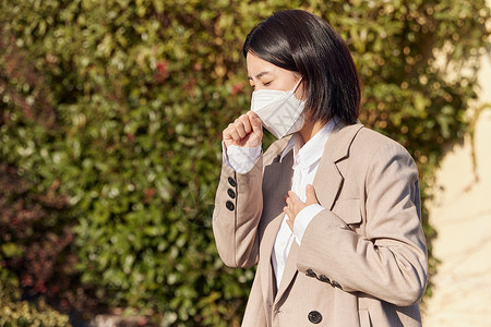 户外带着口罩咳嗽的女性高清图片