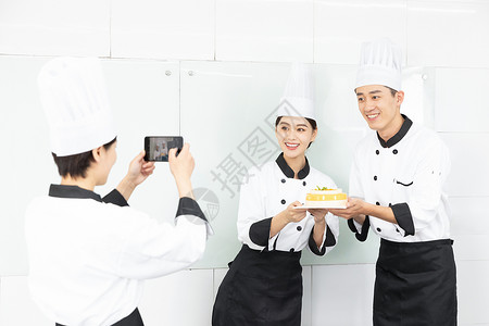 烘焙学校学生手捧蛋糕拍照背景