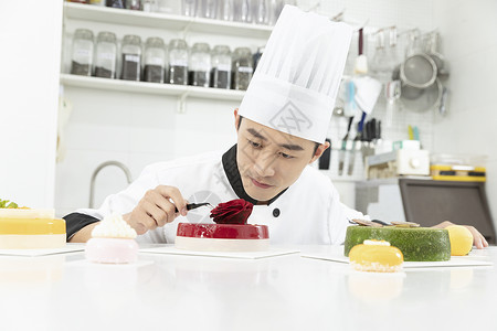男性烘焙师制作水果玫瑰慕斯蛋糕图片