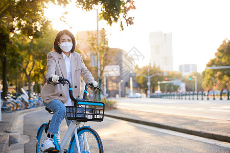 细菌病菌佩戴口罩与手套的都市女性骑共享单车背景