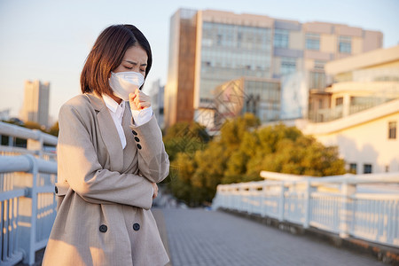 病毒性肺炎户外佩戴口罩咳嗽的青年女性背景