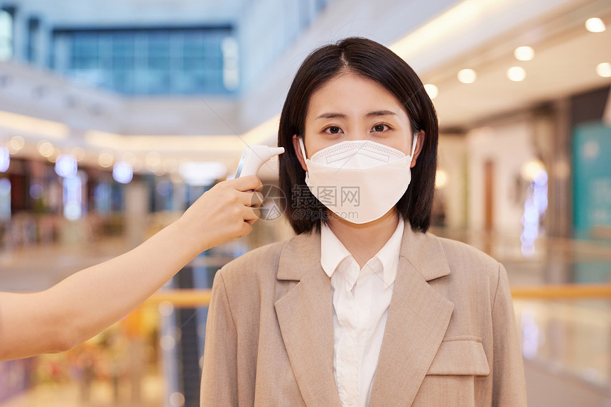 女性佩戴口罩逛商场测量体温图片