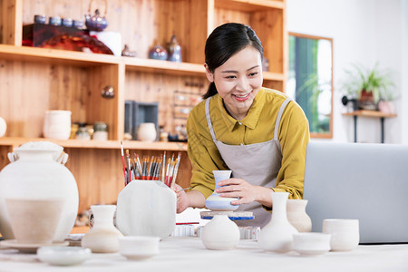 美女陶艺匠人绘制陶艺品背景图片