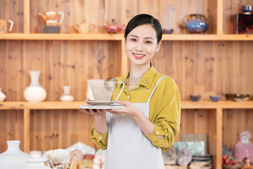 美女匠人展示陶艺品图片