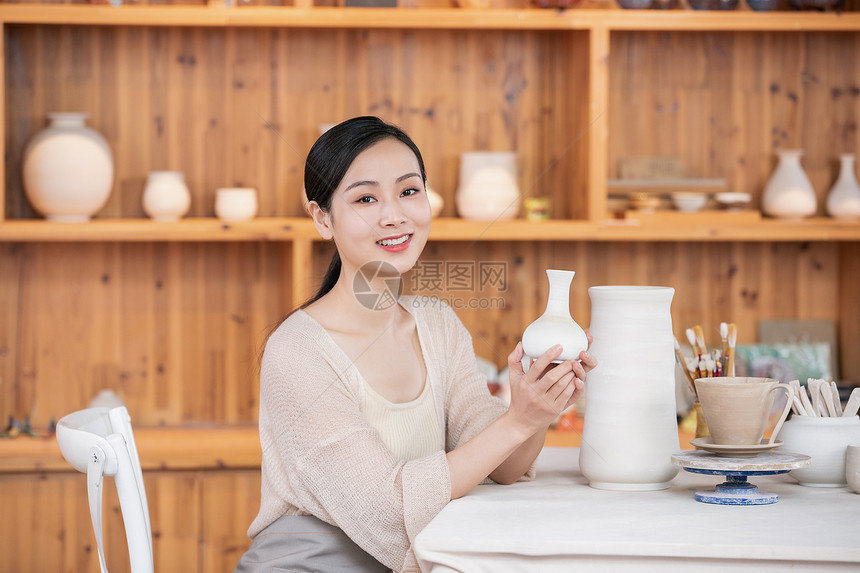 美女陶艺匠人展示陶艺品图片