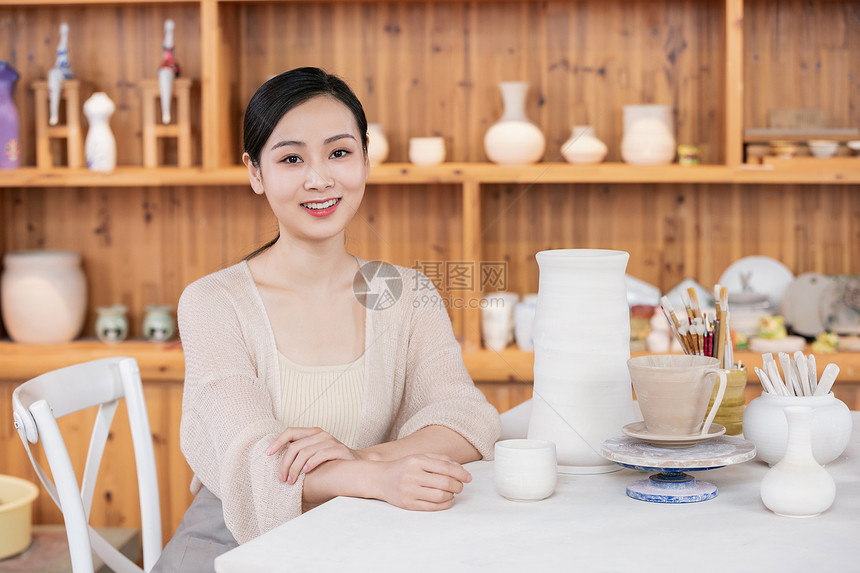 美女陶艺匠人展示陶艺品图片