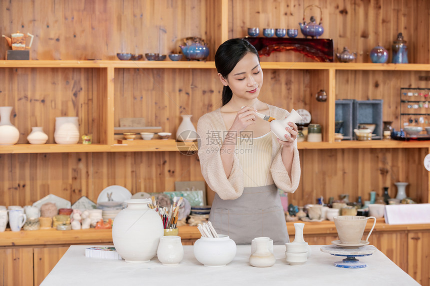 美女陶艺匠人展示陶艺品图片