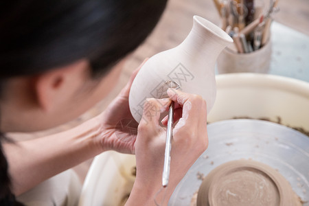 女性手工雕刻陶艺制品特写图片