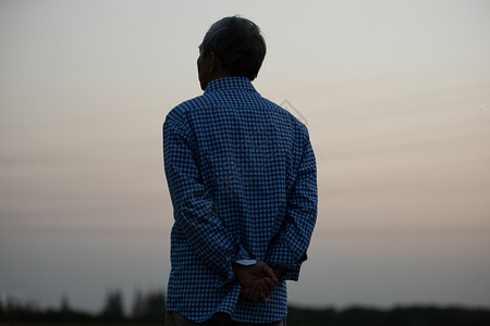 孤独的老人在傍晚望向远方背景图片