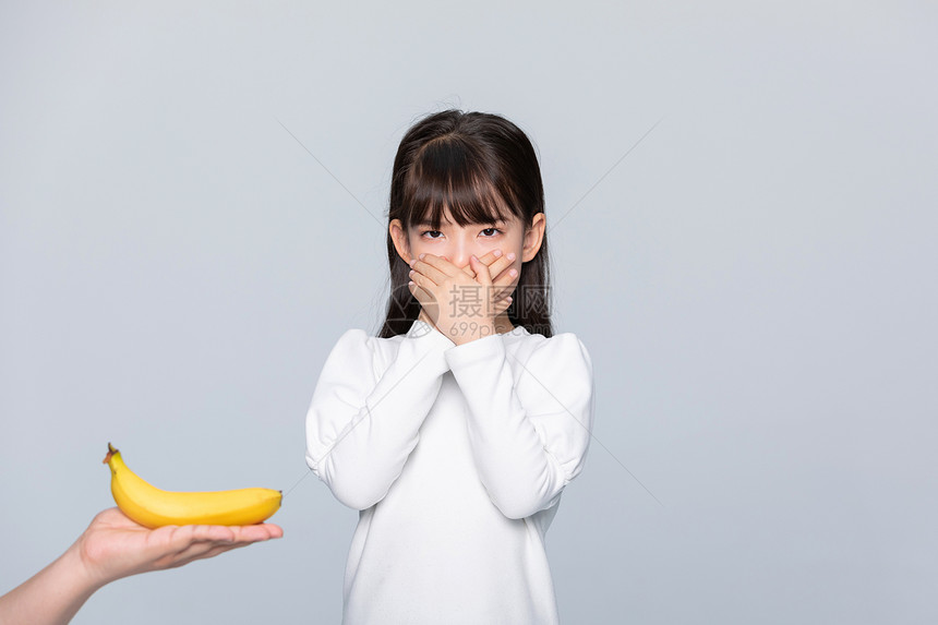 小女孩捂着嘴不想吃水果图片