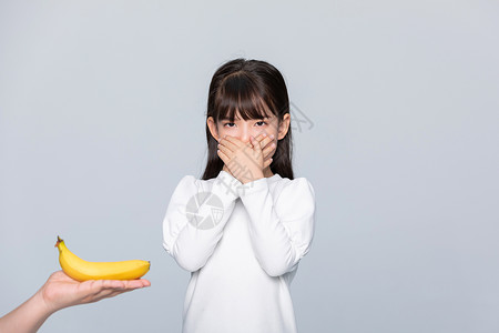 挑食的人小女孩捂着嘴不想吃水果背景